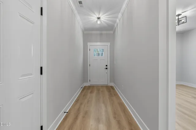 a view of a hallway with a chandelier fan