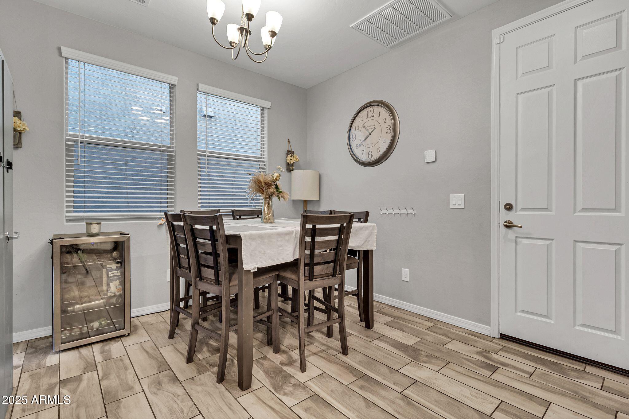 4145 East Bethena Street Gilbert, AZ 85295 - Photo 16 of 60 a view of a dining room with furniture and a chandelier