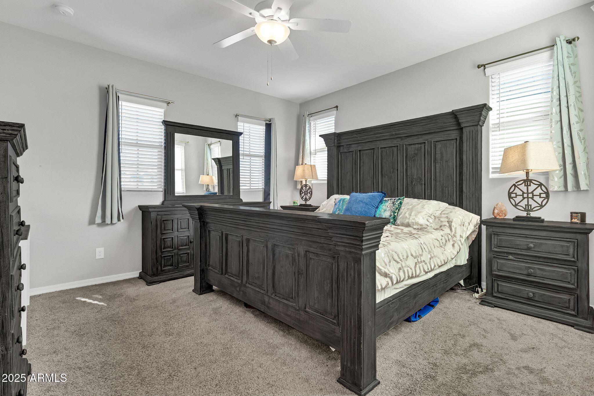 4145 East Bethena Street Gilbert, AZ 85295 - Photo 19 of 60 a bedroom with a bed and a chandelier