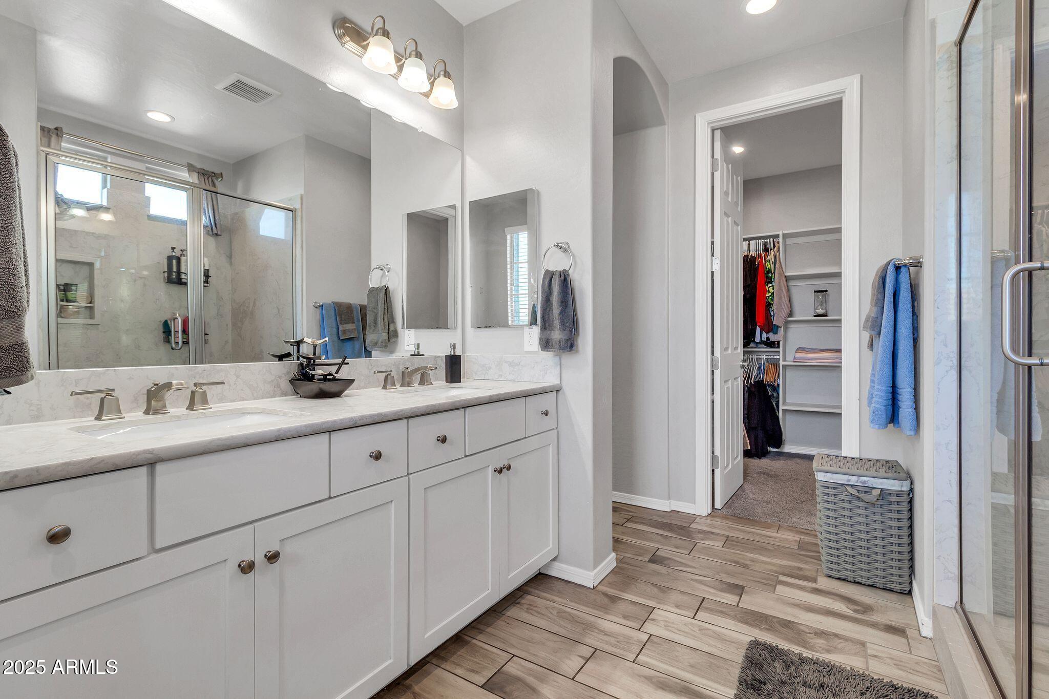 4145 East Bethena Street Gilbert, AZ 85295 - Photo 20 of 60 a bathroom with double vanity sinks a vanity and a mirror