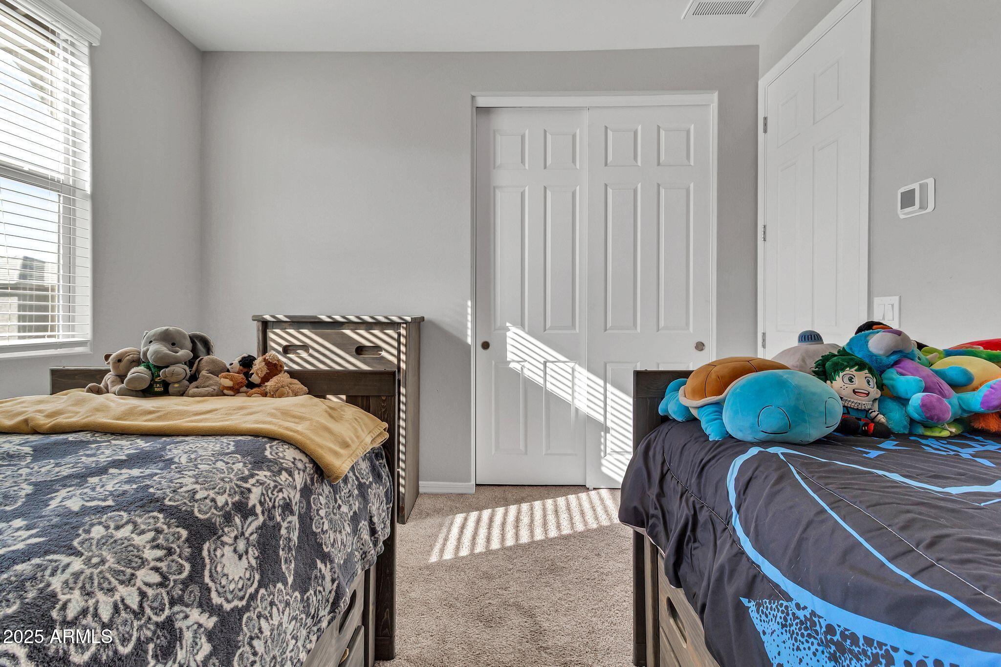 4145 East Bethena Street Gilbert, AZ 85295 - Photo 31 of 60 a bedroom with two beds and a window