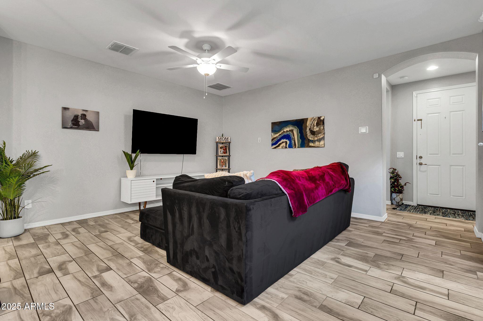 4145 East Bethena Street Gilbert, AZ 85295 - Photo 8 of 60 a living room with furniture and a flat screen tv