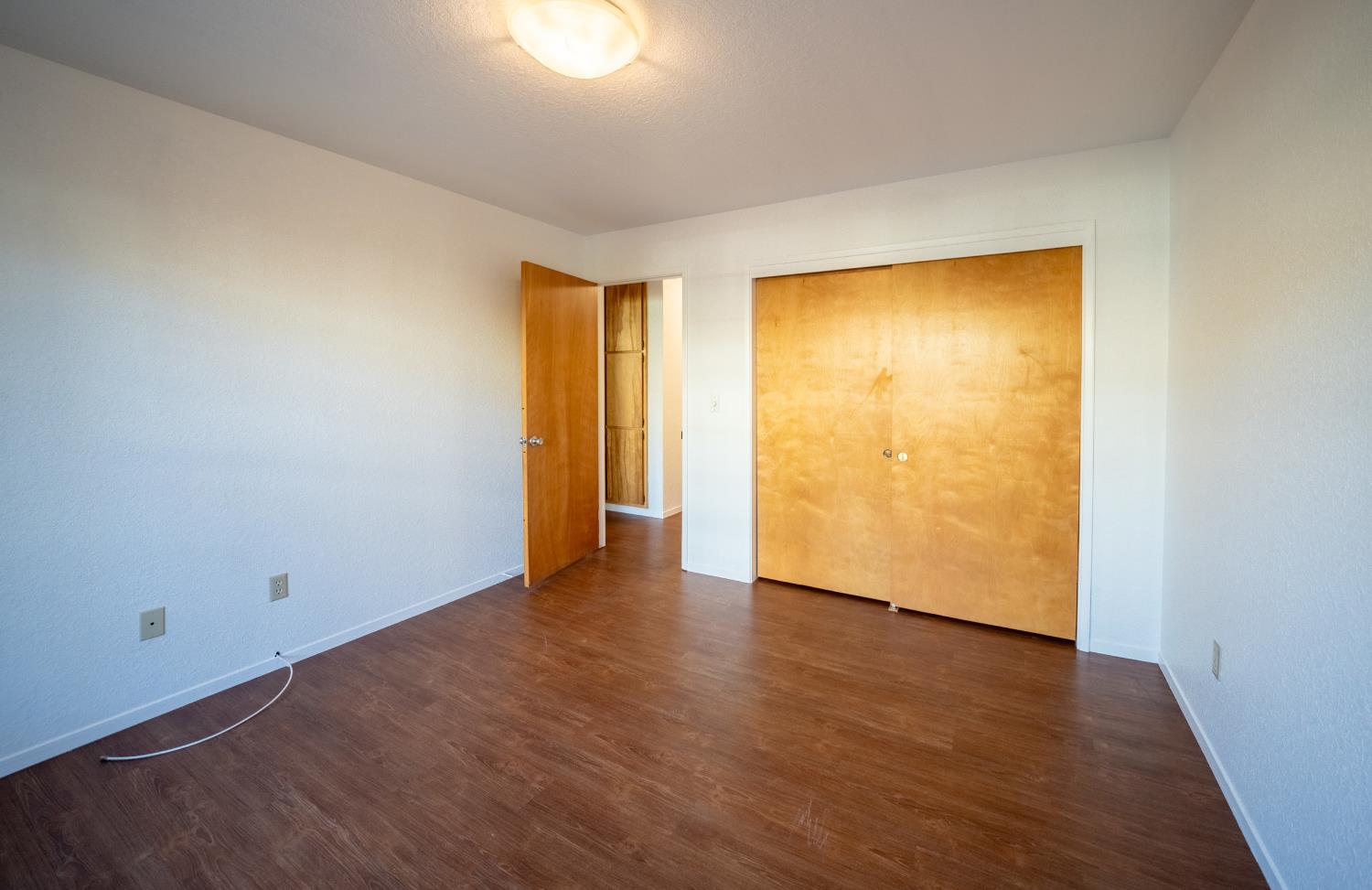 494 Surrey Court Murphys, CA 95247 - Photo 46 of 76 a view of an empty room with wooden floor and a window