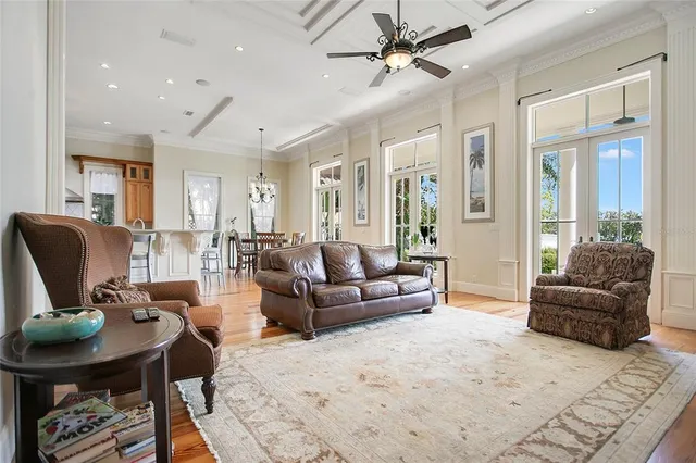 a view of an empty room with wooden floor and a ceiling fan