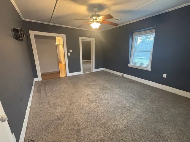 a view of a livingroom with a ceiling fan and window