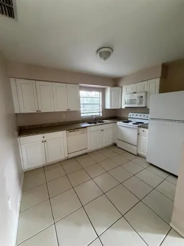 a kitchen with granite countertop cabinets and white appliances