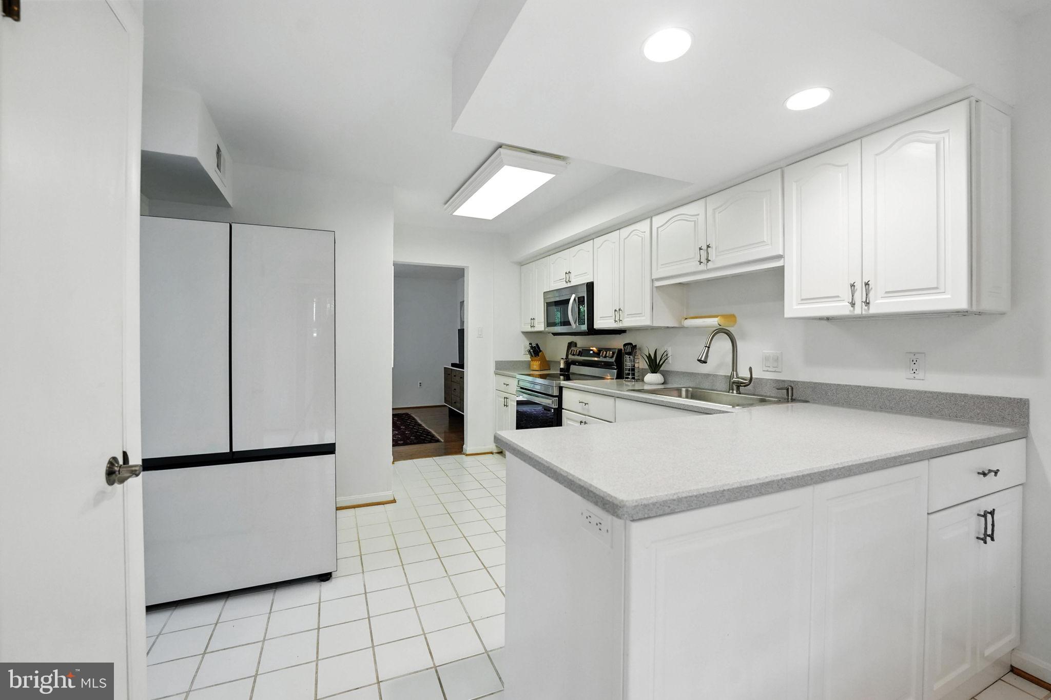 2151 Cabots Point Lane Reston, VA 20191 - Photo 22 of 71 a kitchen with stainless steel appliances granite countertop a refrigerator sink stove and white cabinets