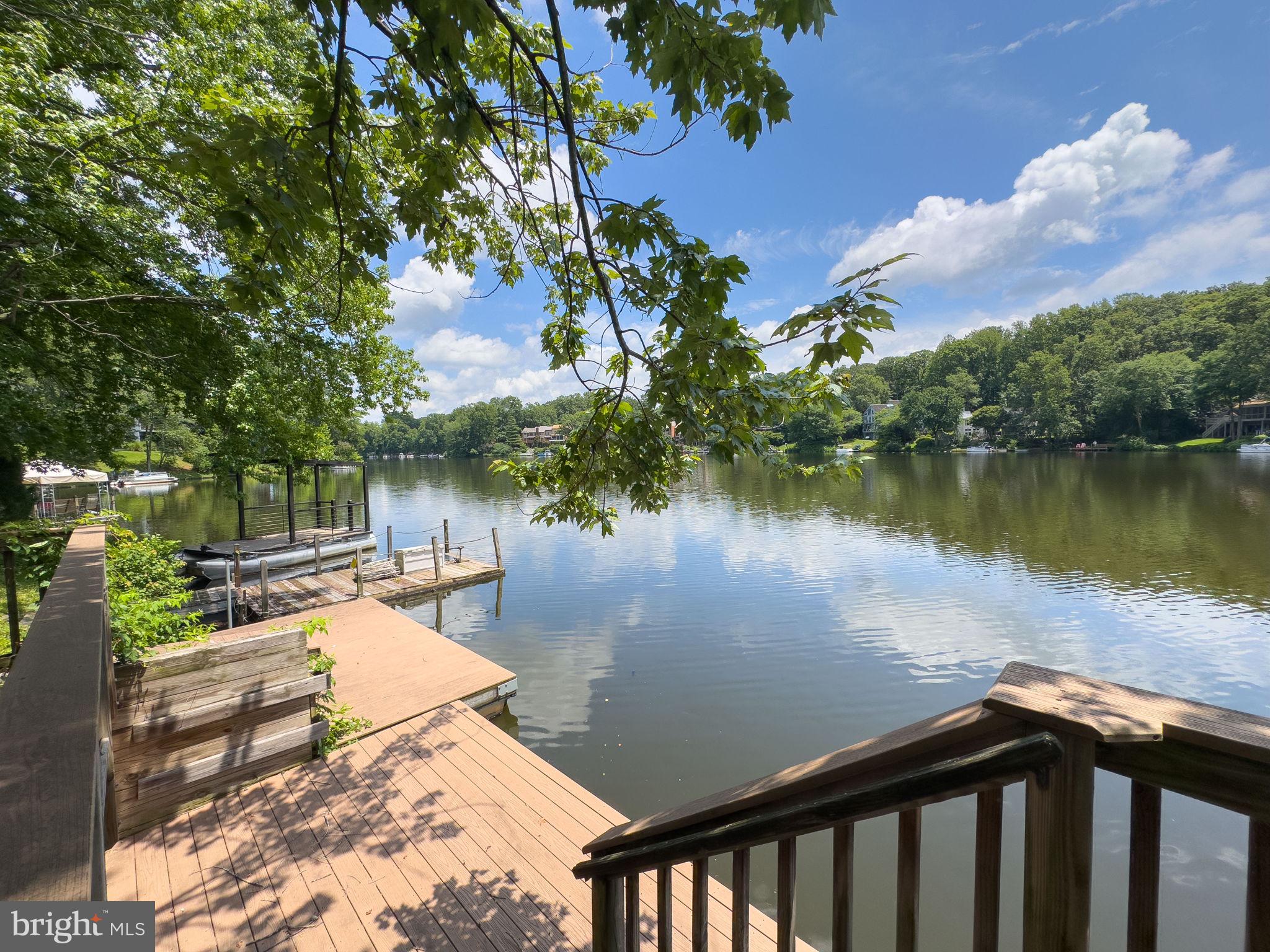 2151 Cabots Point Lane Reston, VA 20191 - Photo 51 of 71 a view of a lake with a floor to ceiling window next to a yard and a large tree