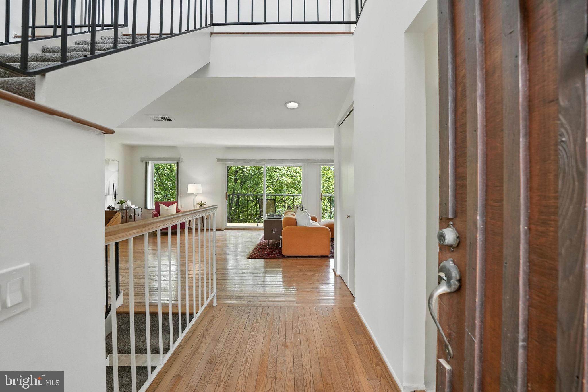 2151 Cabots Point Lane Reston, VA 20191 - Photo 6 of 71 a view of a hallway with wooden floor and a livingroom