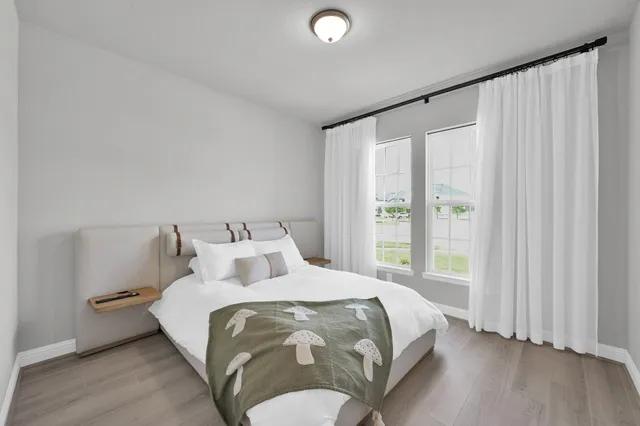 a bedroom with a bed and a large window