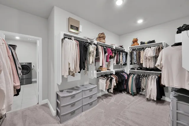 a view of walk in closet with clothes and shoes