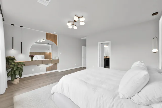 a bedroom with a large bed and a chandelier