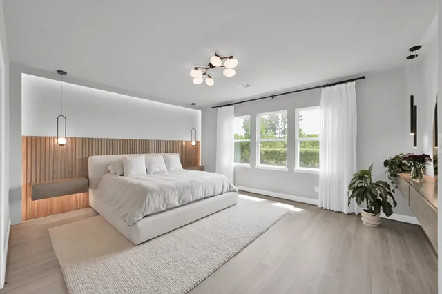a spacious bedroom with a bed and a chandelier