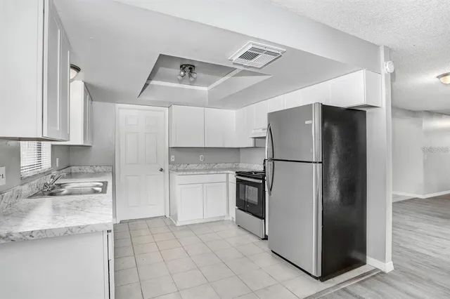 a kitchen with granite countertop a refrigerator and a sink