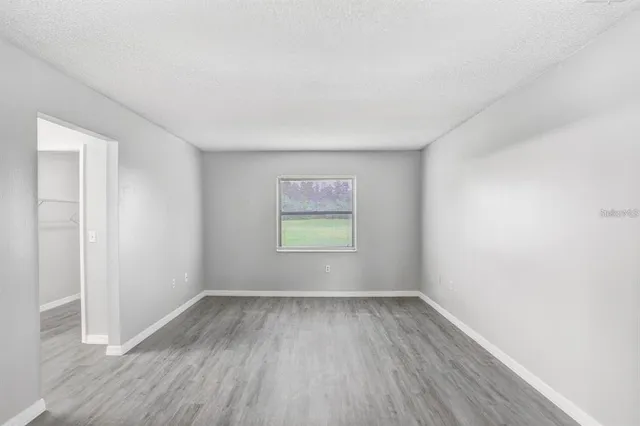 an empty room with wooden floor and window