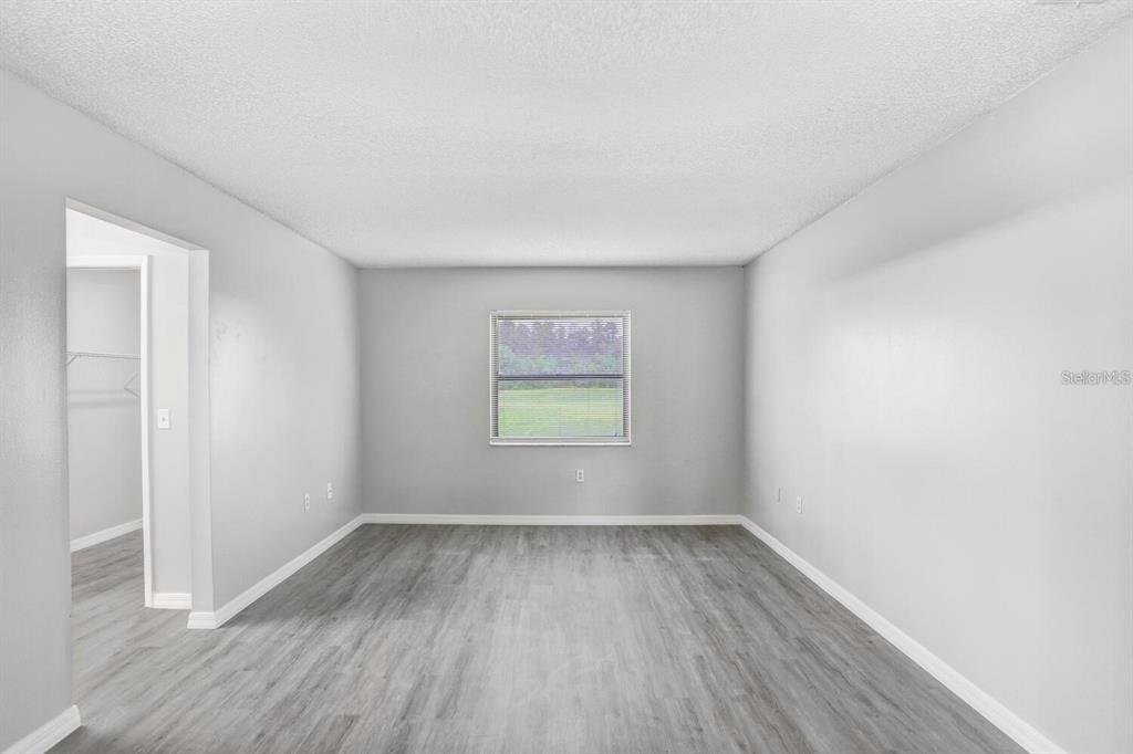 378 Buttonwood Drive Kissimmee, FL 34743 - Photo 13 of 28 an empty room with wooden floor and window