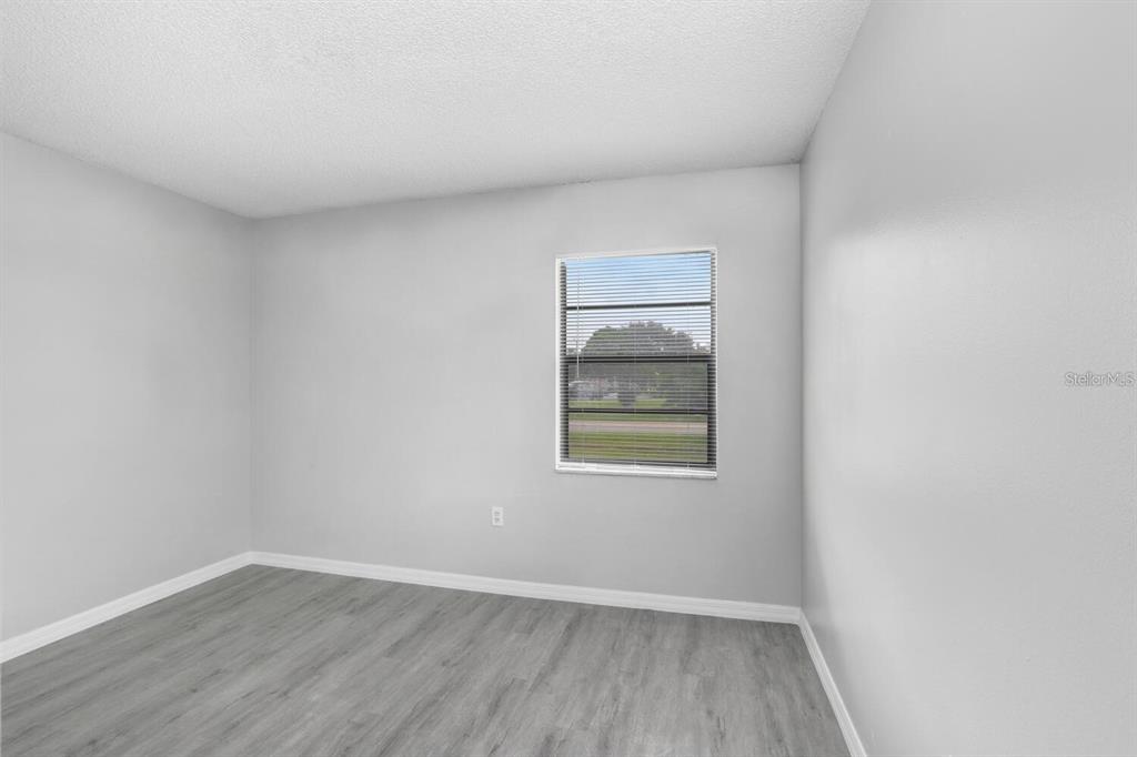 378 Buttonwood Drive Kissimmee, FL 34743 - Photo 19 of 28 an empty room with wooden floor and windows