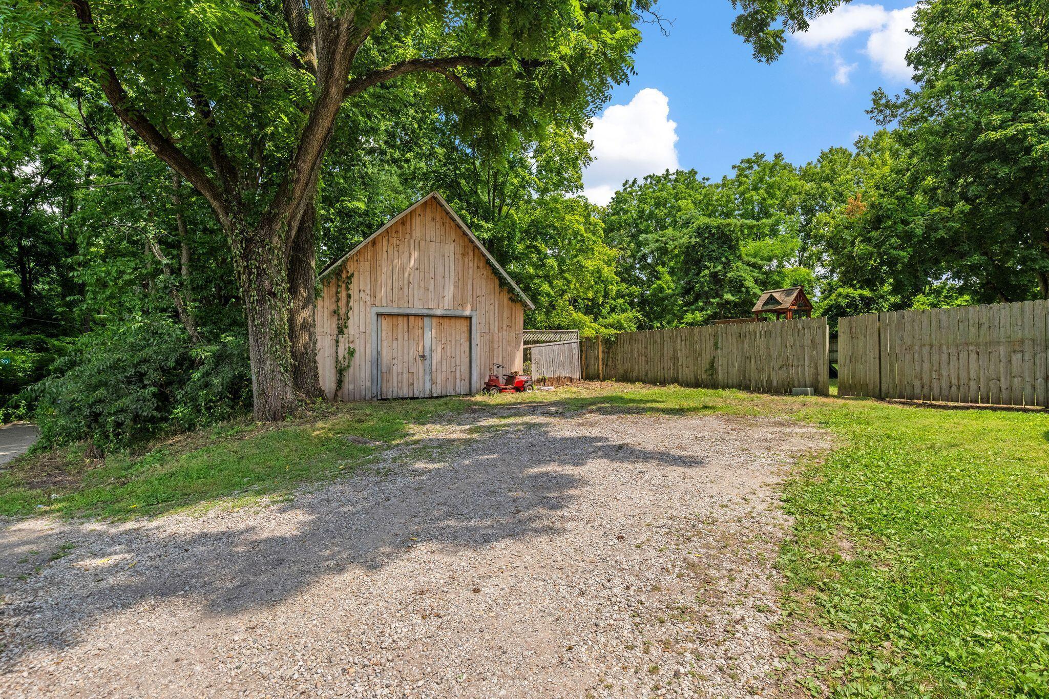 107 Price Road Columbus, OH 43230 - Photo 41 of 51 Spacious gravel driveway with a wood-sided outbuilding featuring double doors