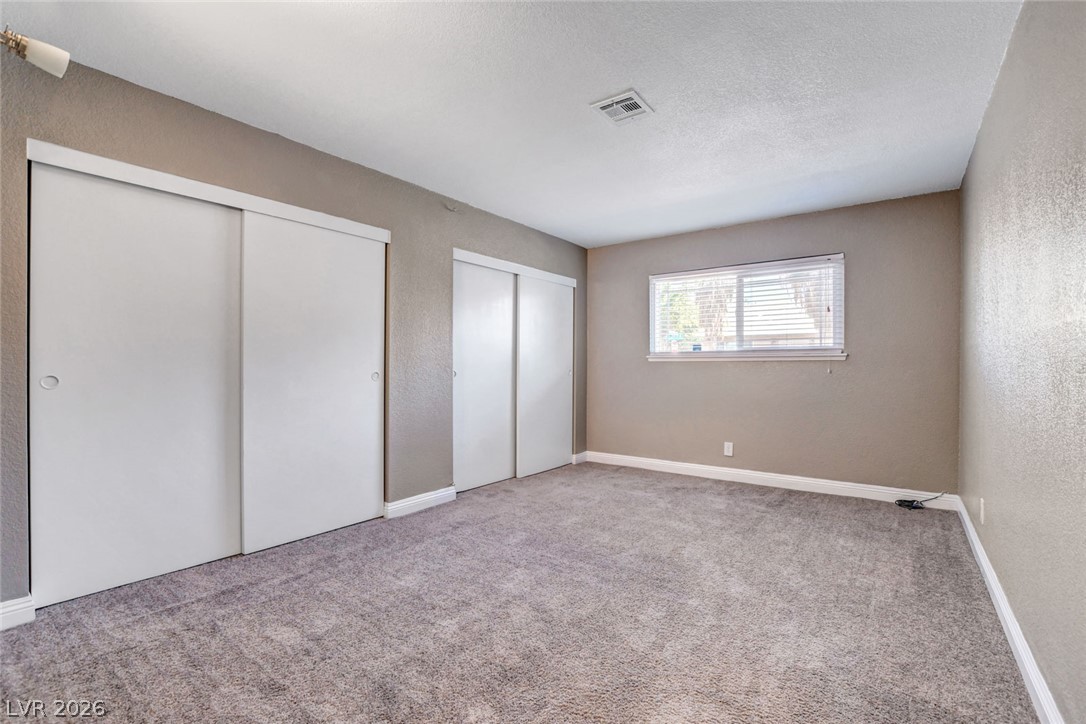 4367 South Mojave Road Las Vegas, NV 89121 - Photo 35 of 53 A well-lit bedroom featuring two spacious closets and plush gray carpeting.
