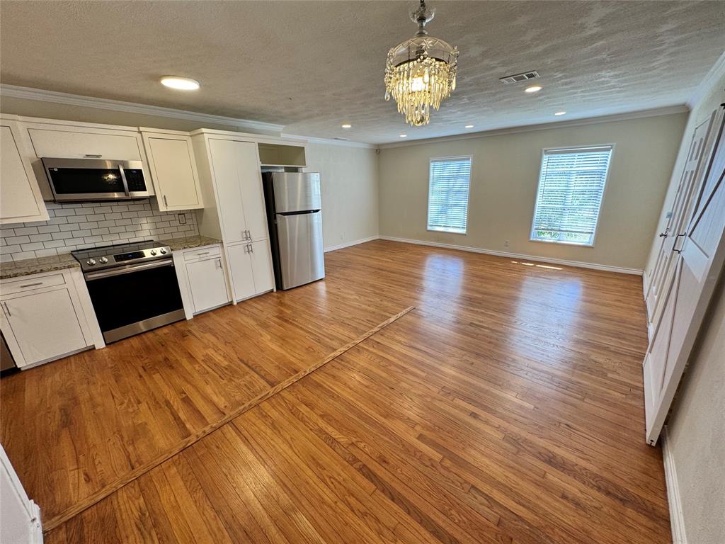 3727 Meredith Avenue Dallas, TX 75211 - Photo 5 of 17 a open kitchen with stainless steel appliances granite countertop a refrigerator stove microwave and cabinets