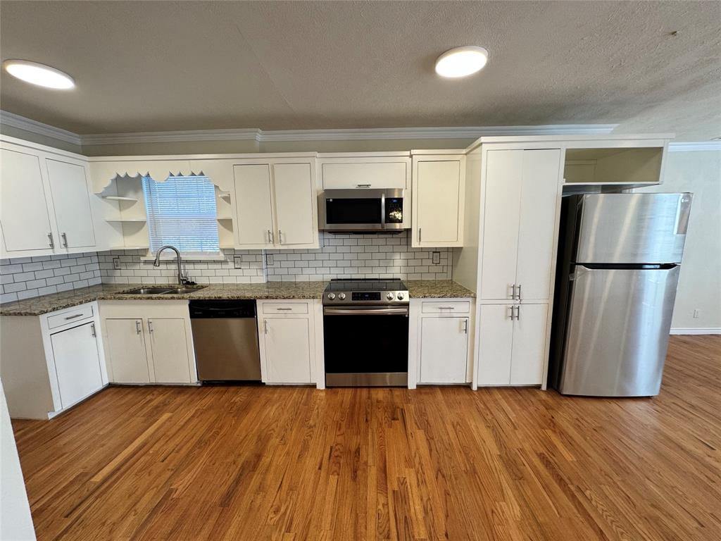 3727 Meredith Avenue Dallas, TX 75211 - Photo 6 of 17 a kitchen with a refrigerator and a stove top oven