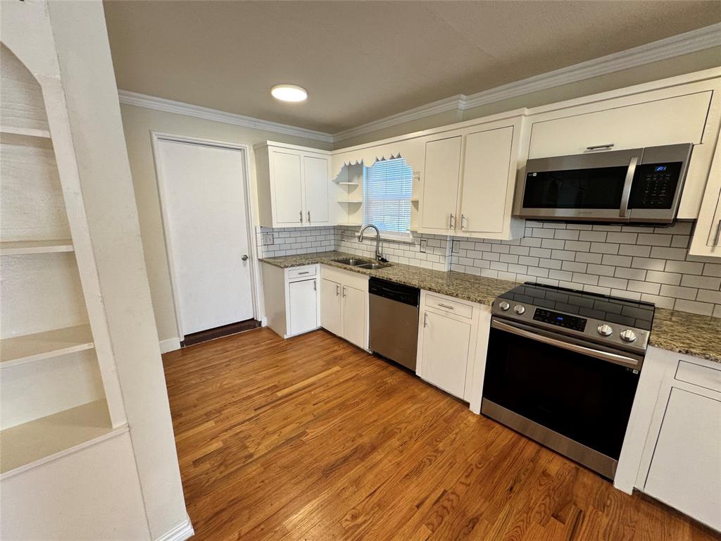 3727 Meredith Avenue Dallas, TX 75211 - Photo 7 of 17 a kitchen with stainless steel appliances granite countertop a stove microwave and sink
