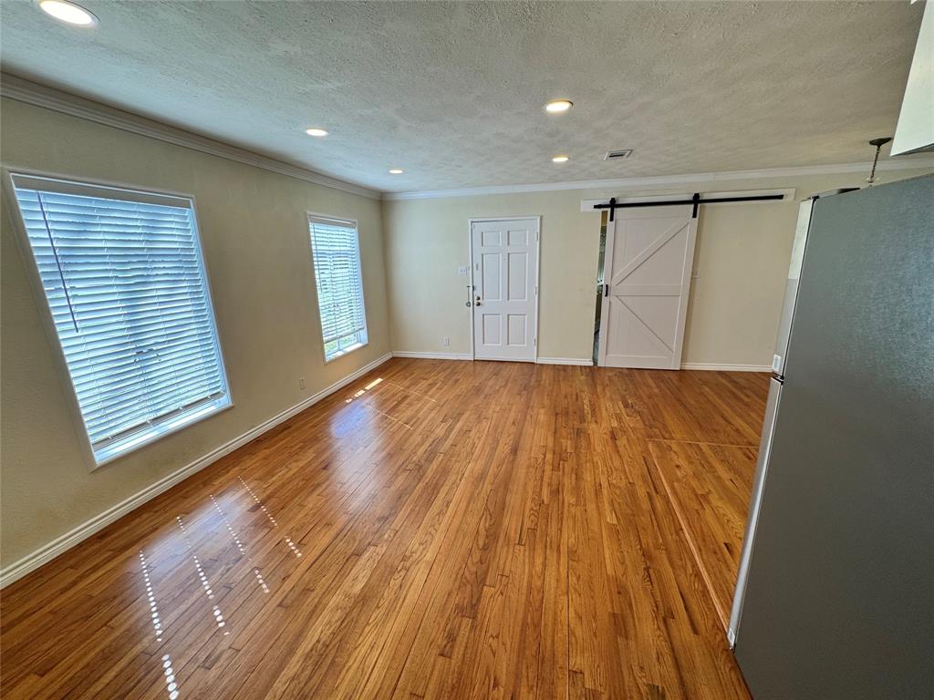 3727 Meredith Avenue Dallas, TX 75211 - Photo 8 of 17 a view of an empty room with wooden floor and a window