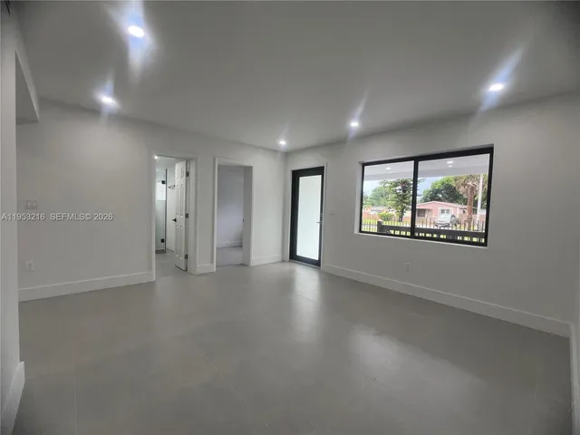 an empty room with windows and ceiling fan