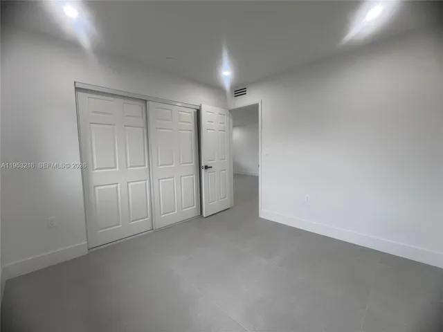 a view of an empty room and chandelier
