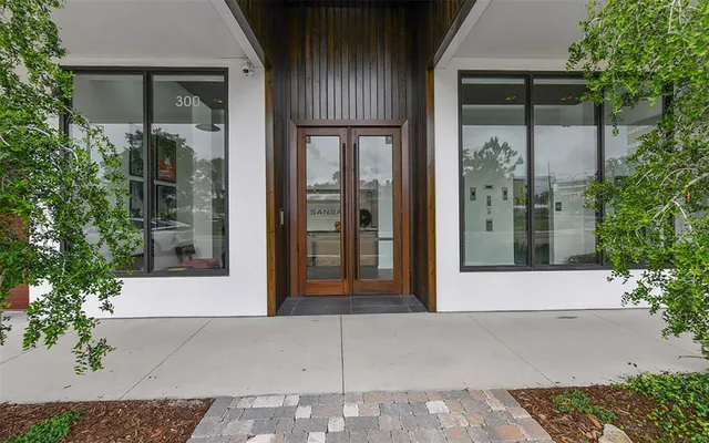 front view of the house with a glass door and potted plants