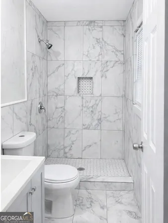 a bathroom with a toilet sink and shower