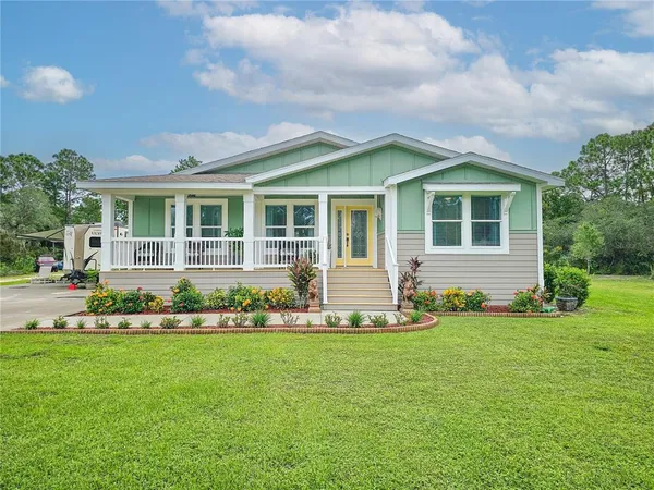 a front view of house with a garden and trees