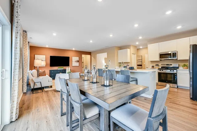 a view of a dining room with furniture wooden floor and a flat screen tv