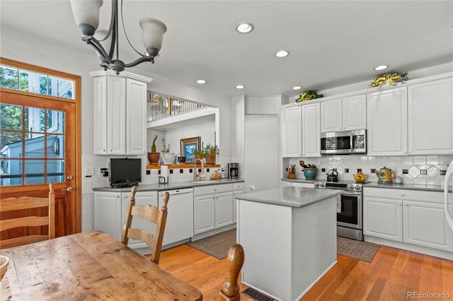 a kitchen with granite countertop a sink appliances cabinets and furniture