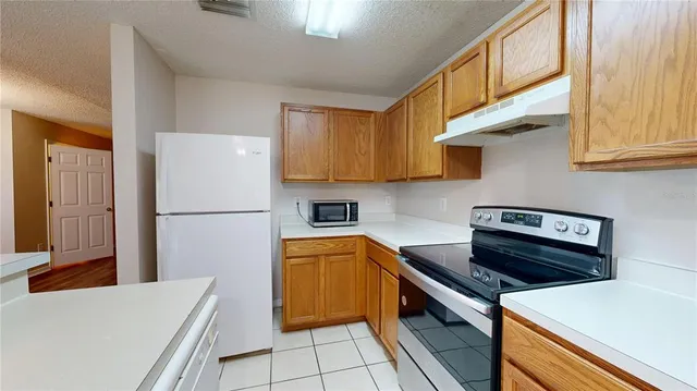 a kitchen with a refrigerator a stove top oven a sink and cabinets