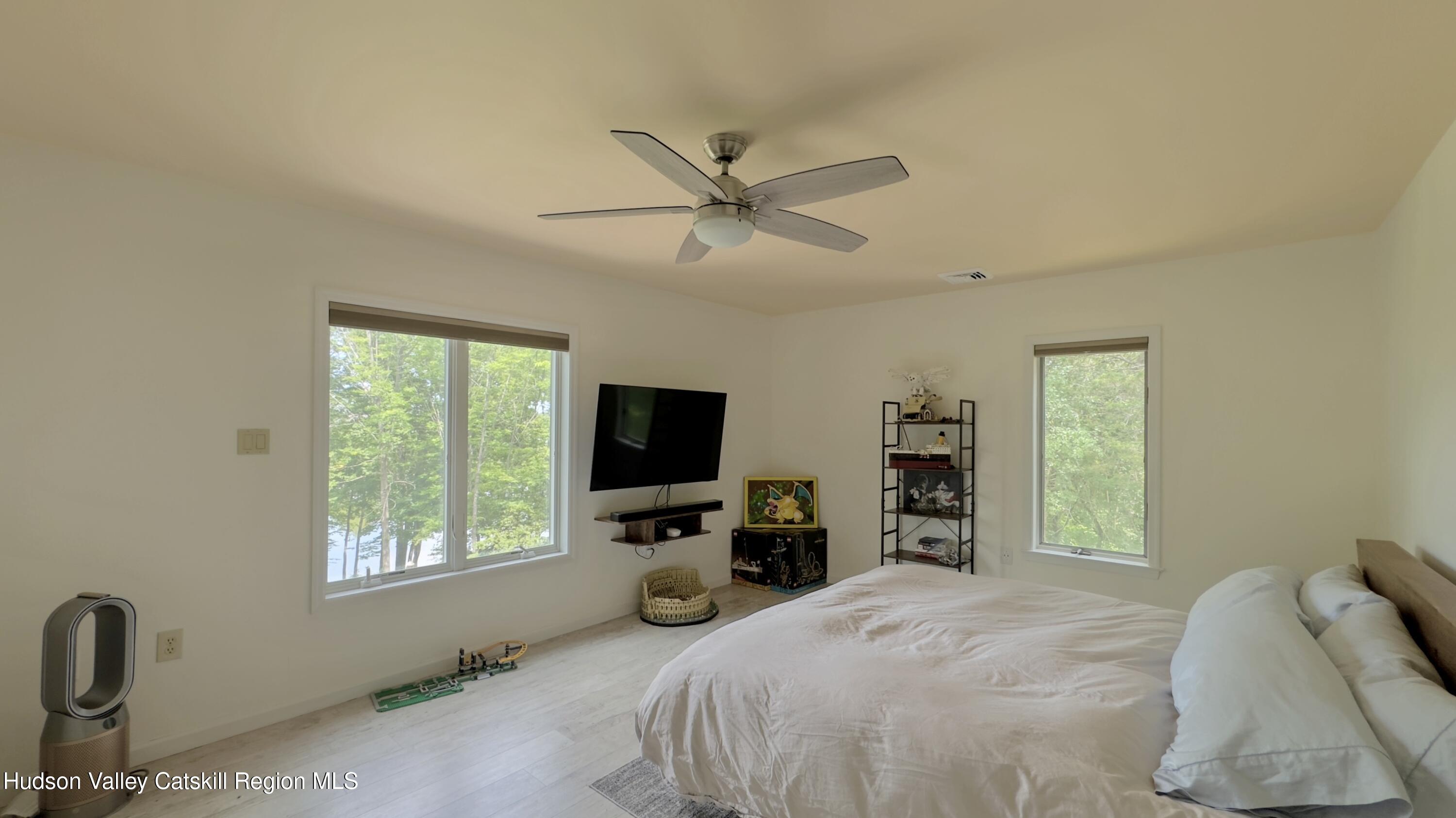 3223 Sleepy Hollow Road Athens, NY 12015 - Photo 32 of 73 a bedroom with a bed and a flat tv screen on dresser