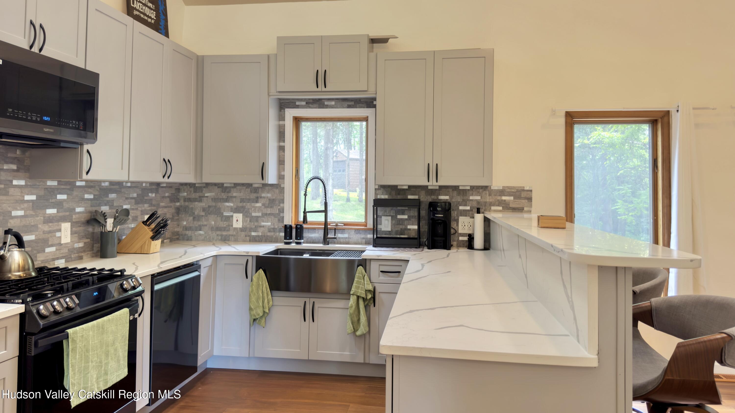 3223 Sleepy Hollow Road Athens, NY 12015 - Photo 8 of 73 a kitchen with stainless steel appliances kitchen island granite countertop a stove a sink dishwasher and white cabinets with wooden floor