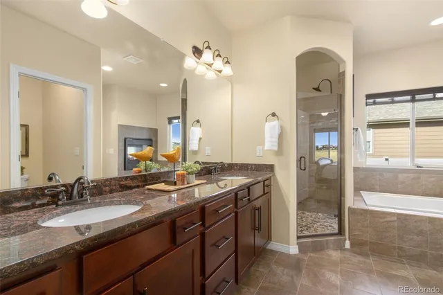 a bathroom with a granite countertop sink a large mirror and a shower