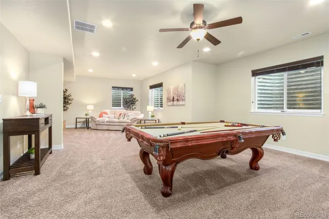a room with furniture pool table and windows