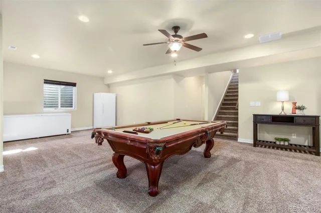 a living room with a pool table and windows