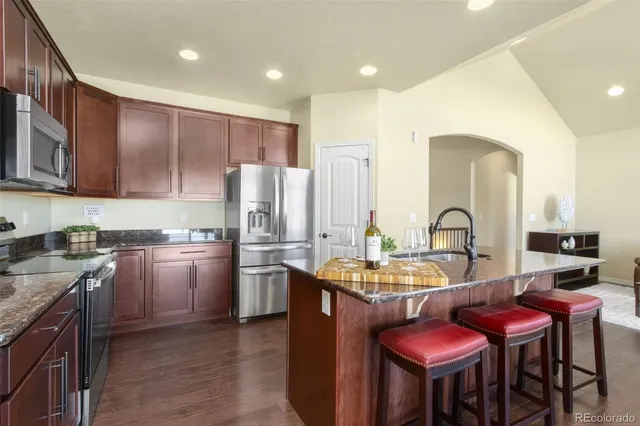 a kitchen with stainless steel appliances kitchen island granite countertop a kitchen island a stove a table and chairs in it