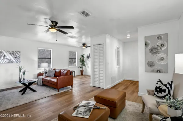 a living room with furniture and a wooden floor