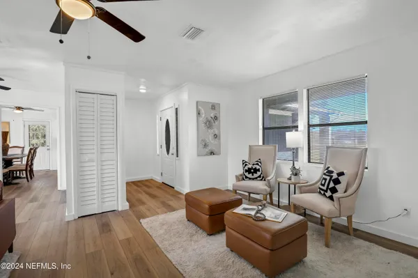 a living room with furniture potted plant and wooden floor