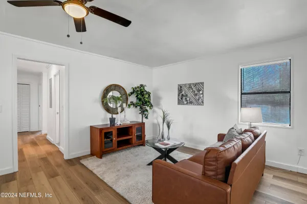 a living room with furniture a ceiling fan and a rug
