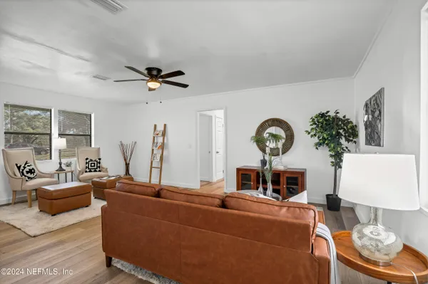 a view of a hallway with wooden floor and a clock on a wall