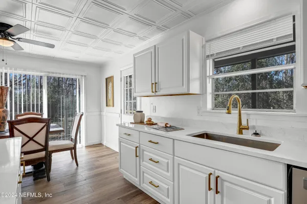 a kitchen with cabinets stainless steel appliances a sink and wooden floor