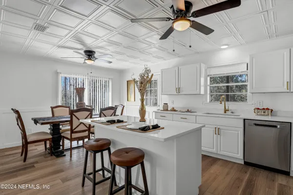 a kitchen with a dining table chairs sink and cabinets