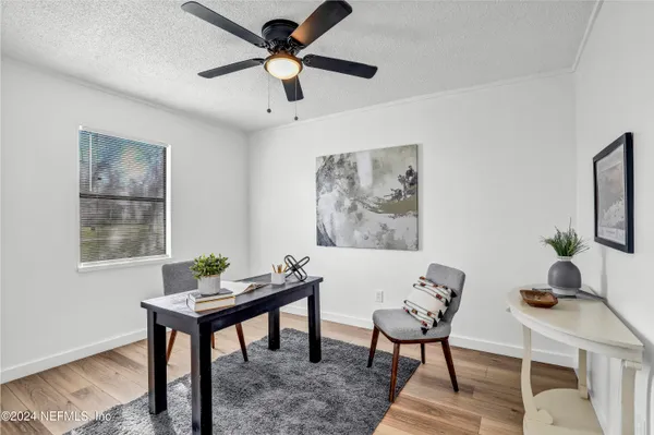 a view of a workspace with furniture and a window