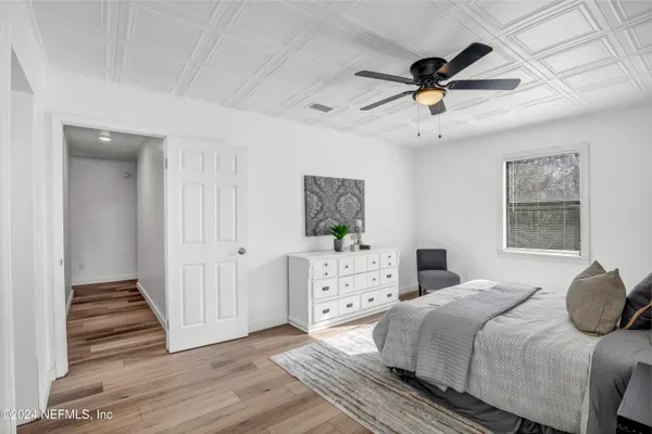 a bedroom with a bed and wooden floor