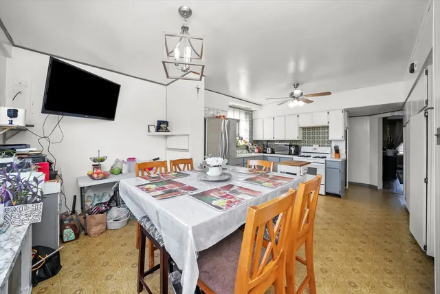 a open kitchen with stainless steel appliances kitchen island granite countertop a stove top oven a sink dishwasher and white cabinets with wooden floor